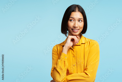 Portrait of beautiful, smiling Asian woman wearing stylish casual yellow shirt choosing something