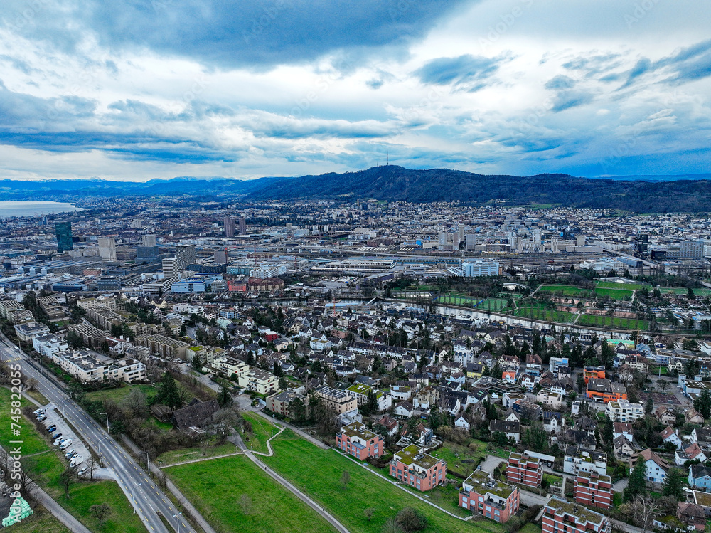 Aerial view from Hönggerberg over Swiss City of Zürich with lake and Swiss Alps in the background on a cloudy winter afternoon. Photo taken February 24th, 2024, Zurich, Switzerland.