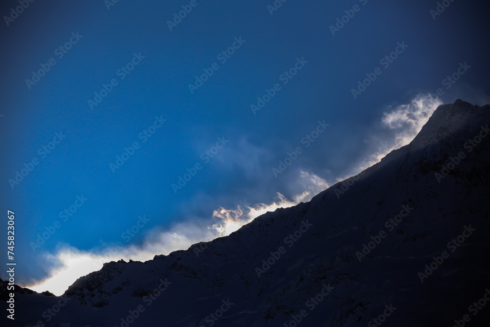 Obraz premium strong winds at the snowy mountain ridge above Saas-Fee