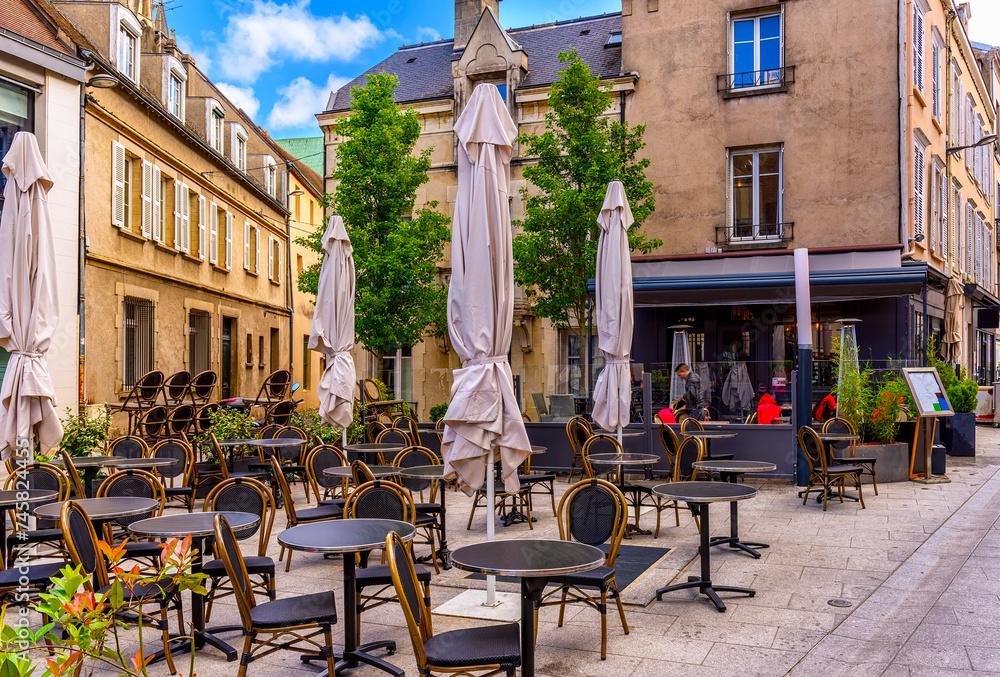 Old street with old houses and tables of cafe in a small town Chartres, France