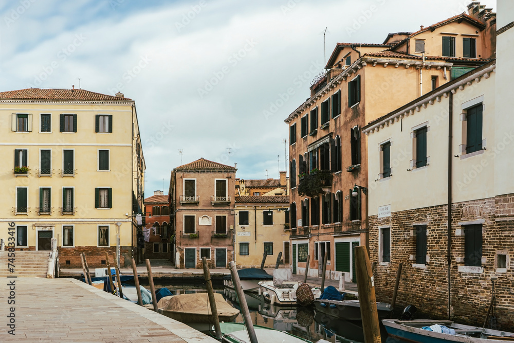 Channel in Venice - boat and old town houses