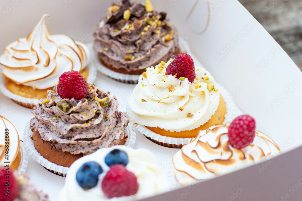 Assorted cupcakes in gift box with chocolate, vanilla and oreo cream, whipped meringue, raspberry, blueberry and bites of chocolate Assorted cupcakes in gift box with chocolate, vanilla and oreo cream, whipped meringue, raspberry, blueberry and bites of chocolate