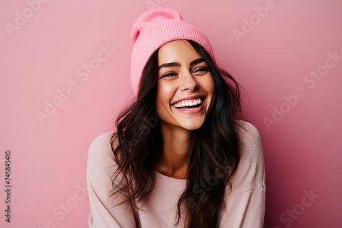 Portrait of a beautiful young woman in pink hat and sweater smiling