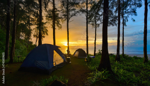 Camping on the lake beach in the forest, at the sunset.