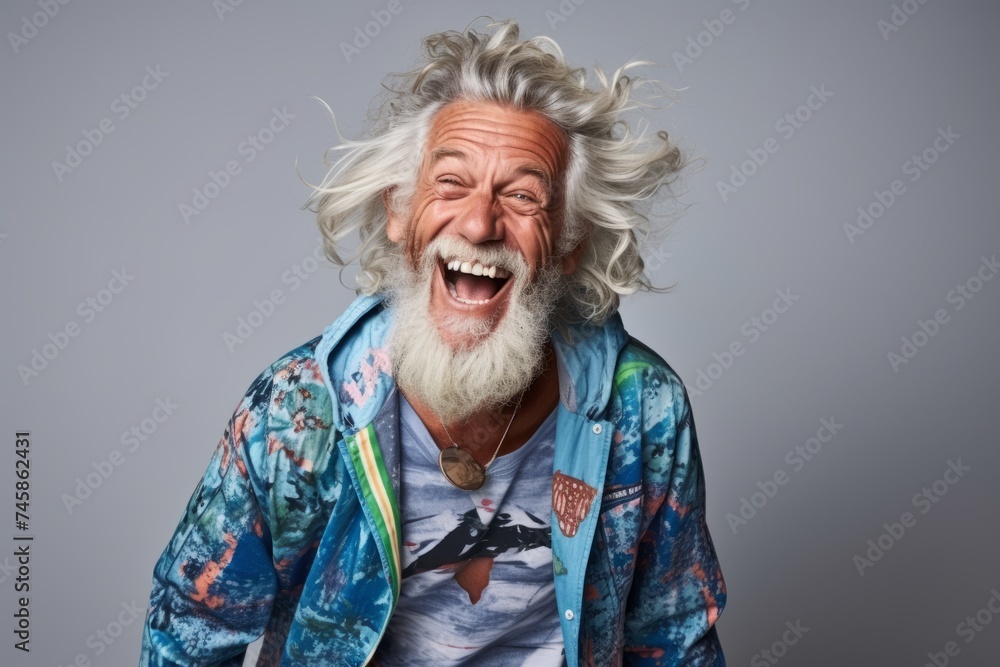 Portrait of a happy senior man with long white hair laughing against a grey background Portrait of a happy senior man with long white hair laughing against a grey background