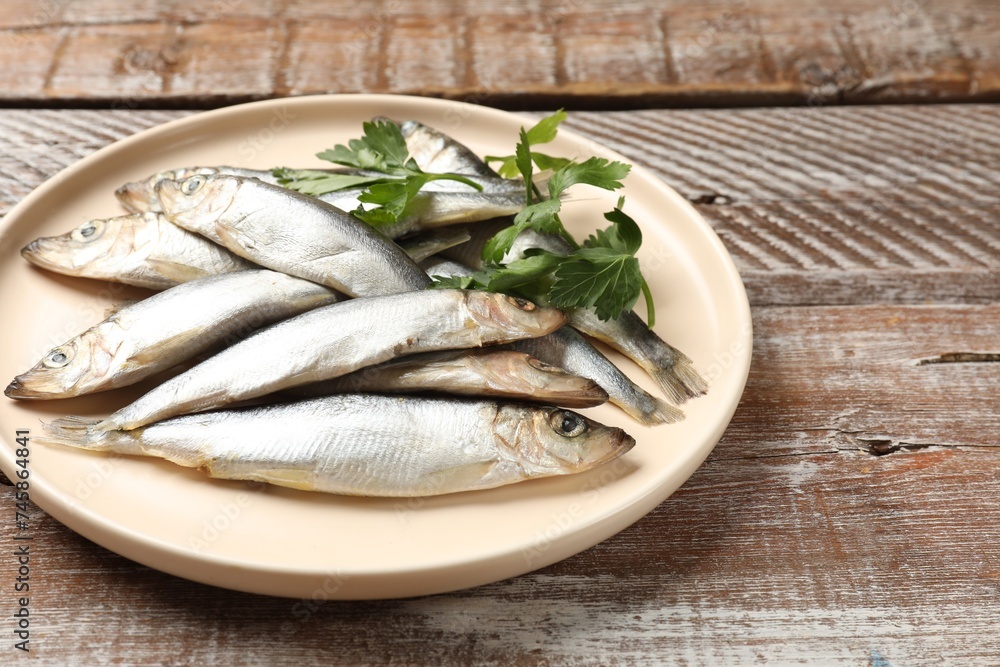 Fresh raw sprats and parsley on wooden table, closeup Fresh raw sprats and parsley on wooden table, closeup