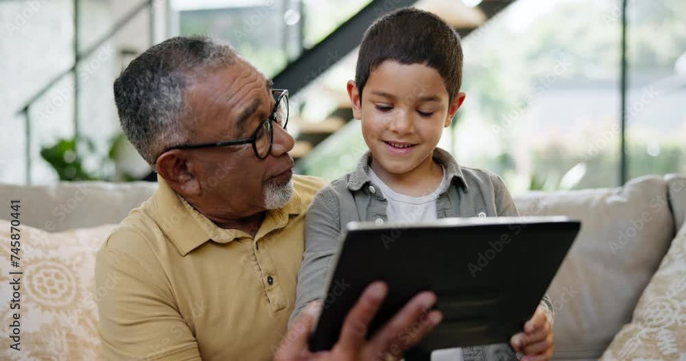 Tablet, education or game with grandfather and boy on sofa in living room of home together for visit. Family, technology or social media app with senior man and grandson in apartment for learning Tablet, education or game with grandfather and boy on sofa in living room of home together for visit. Family, technology or social media app with senior man and grandson in apartment for learning