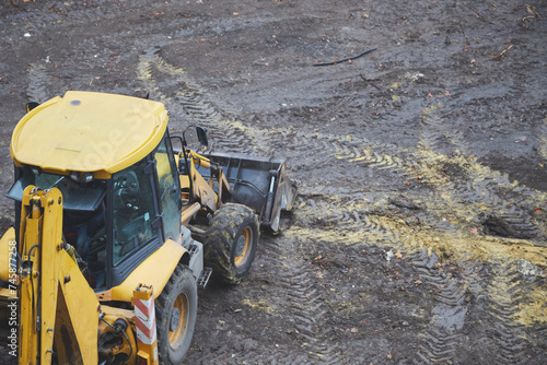  A yellow bulldozer stands on a cleared land plot, the beginning of construction, the work of a bulldozer at a construction site