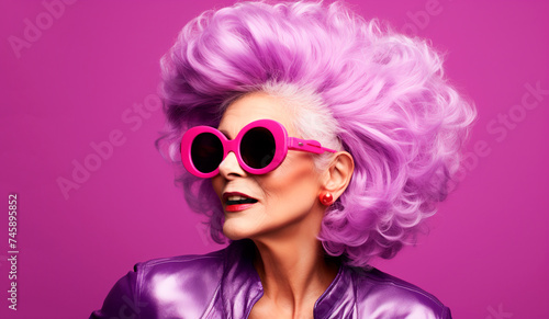 Beautiful modern elderly woman with violet hair close-up on a purple background in a leather jacket  voluminous hairstyle  styling  portrait