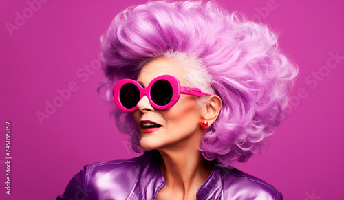 Beautiful modern elderly woman with violet hair close-up on a purple background in a leather jacket, voluminous hairstyle, styling, portrait