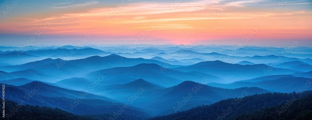 Serene Mountain Sunset: Ethereal Haze and Warm Light Blending Ridges from Blues to Oranges