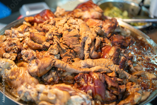 Close-up at part of pork meat and entrails that are stewed on the boiling pot to cooking as the pork leg menu. Thai street food menu, selective focus.