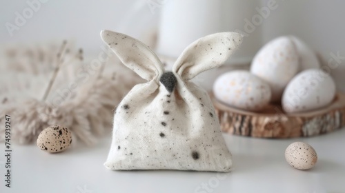 Happy Easter decoration concept holiday greeting card - Fabric gift bag with easter bunny ears and easter eggs on white table
