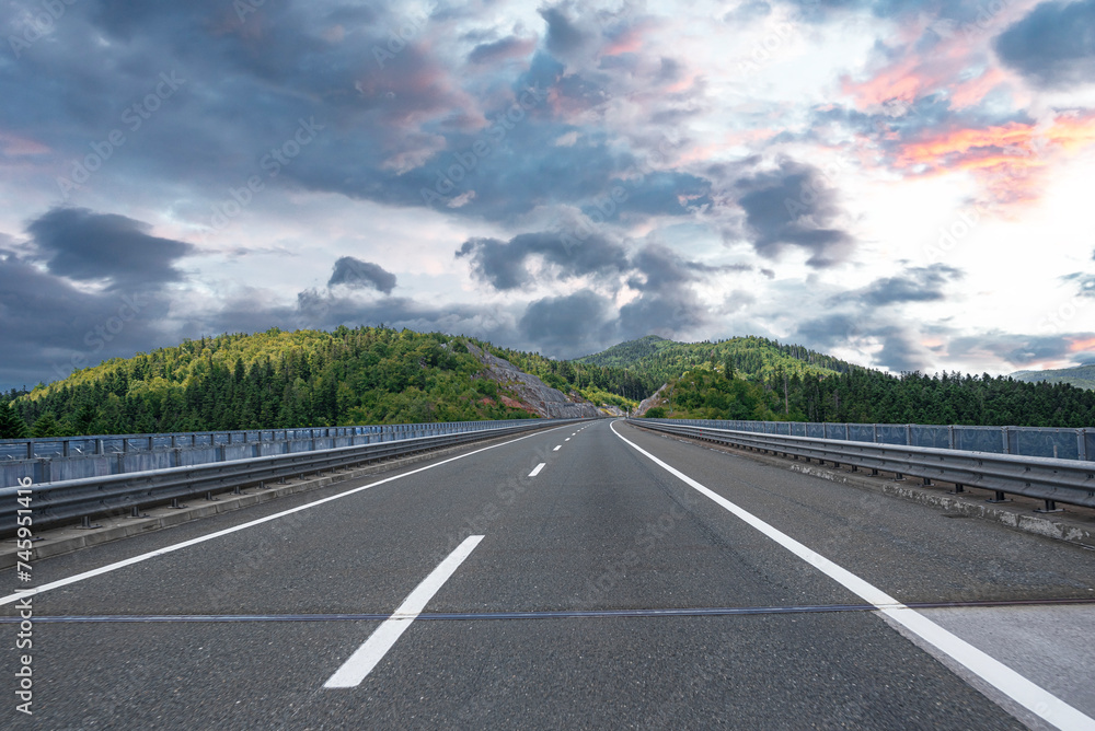 Fototapeta premium Country road with rocky mountains in the background.