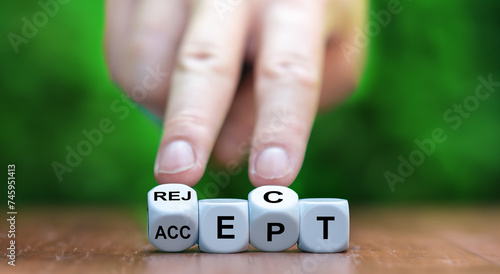 Hand turns dice and changes the word accept to reject. photo