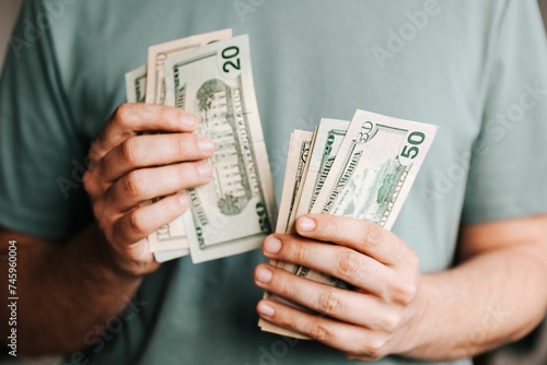 Crop man counting dollar banknotes 