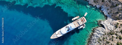 Aerial drone ultra wide top down photo with copy space of luxury yacht anchored in tropical exotic island with crystal clear turquoise sea © aerial-drone