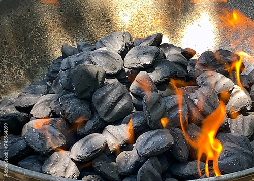 фотографія Charcoal briquettes on fire in the family grill