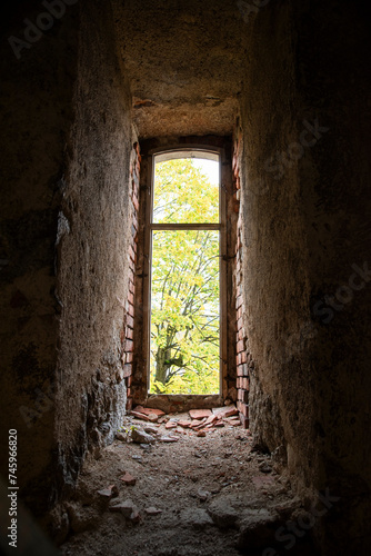 Old window in an abandoned ruined building overlooking the park. © Kozioł Kamila
