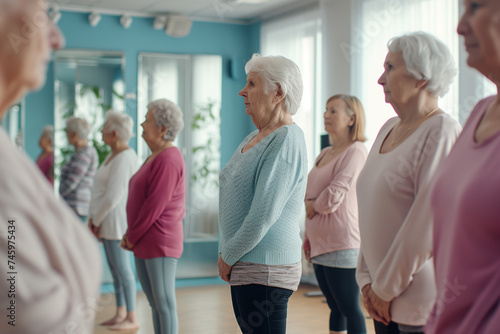 Group of elderly women standing at the mirror in a ballet position in a dance studio