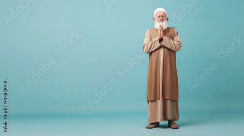 Muslim old man, studio portrait and islamic culture standing isolated on studio background with arabic clothes.