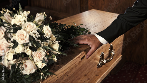 coffin at a funeral with a hand on top © Charlie