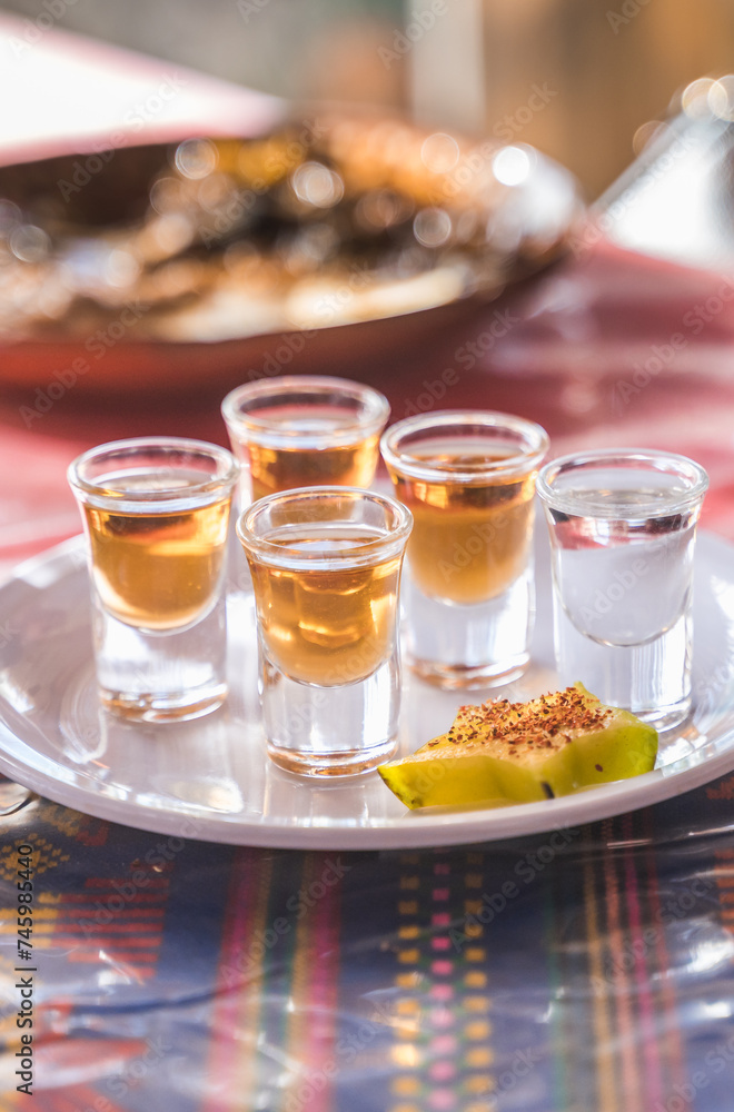 Mezcales, a typical Mexican drink served in glass horses, natural and combined with plum, accompanied by a star fruit with chili powder. Mezcales, a typical Mexican drink served in glass horses, natural and combined with plum, accompanied by a star fruit with chili powder.