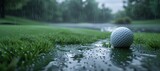 Close-up of a golf ball lying on wet grass with fresh rain droplets falling around it in a serene golf course