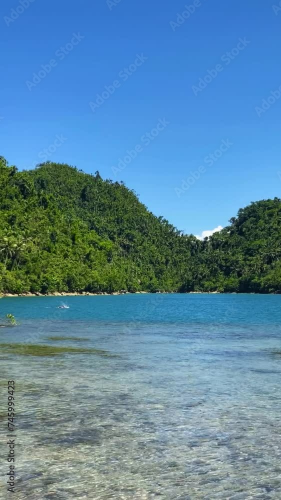 A man swimming in lagoon in Tinago Island. Tagana-an, Surigao del Norte. Philippines. Vertical view. A man swimming in lagoon in Tinago Island. Tagana-an, Surigao del Norte. Philippines. Vertical view.