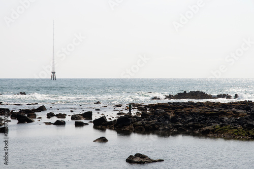 View of the steel tower on the sea horizon