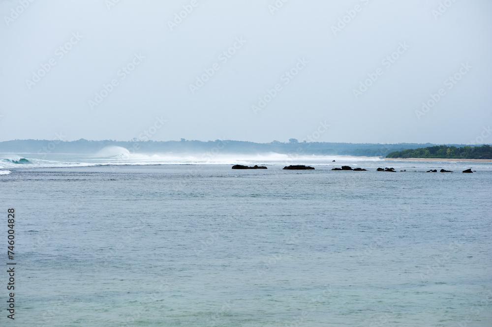 Olas y contra olas en el rompiente al atardecer en la playa de Ujung Genteng, Sukabumi, Java, Indonesia 