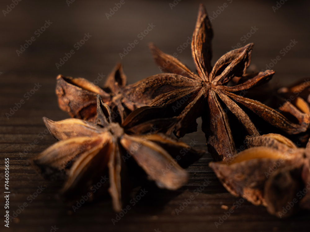 anise star on a dark surface with other seeds in the foreground