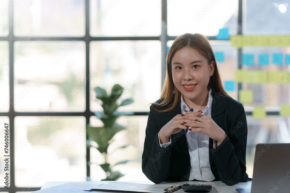 Confident asian businesswoman at her desk in a modern office. Corporate professionalism and leadership concept. Confident asian businesswoman at her desk in a modern office. Corporate professionalism and leadership concept.