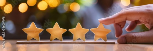 Hand rating with five golden stars - A hand placing the fifth golden star in a row, symbolizing top quality service or product rating