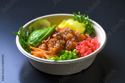 Take away Poke bowl with salmon, avocado, pickled cucumbers, carrots, edamame beans, salad, rice and sesame 
