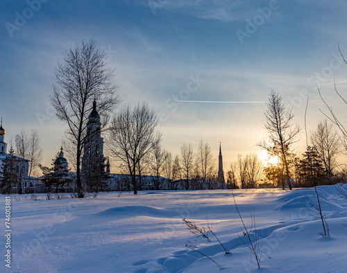 Winter landscape at sunset, frosty evening, view of ancient Slavic architecture.