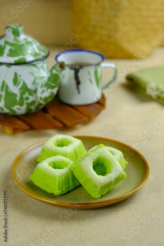 A plate of Putu Ayu on brown background. Indonesian traditional sponge cake with grated coconut on top. . Kue tradisional