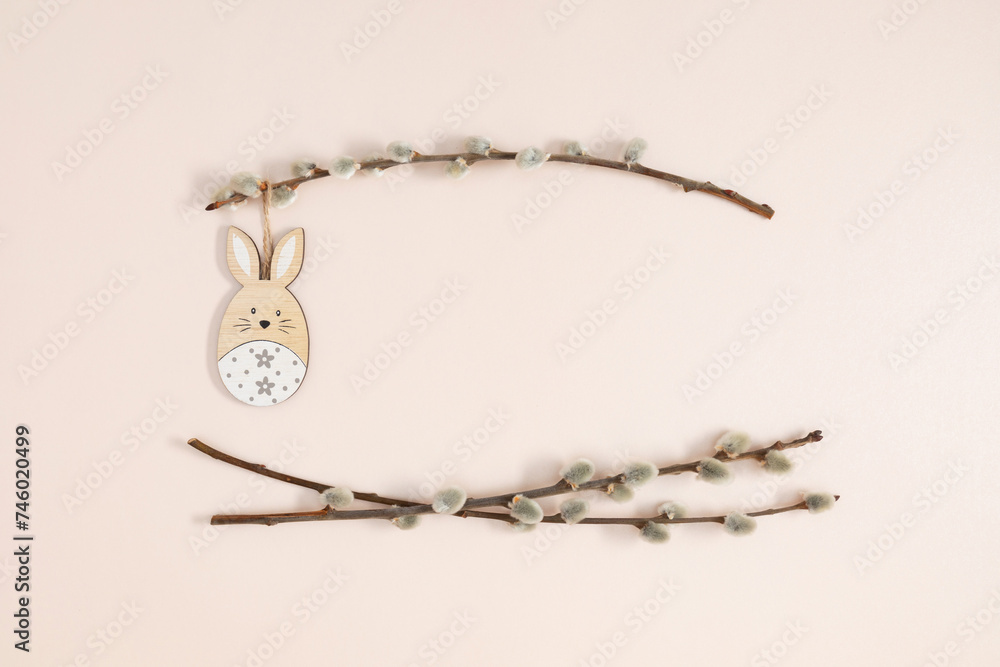 Fototapeta premium Happy Easter concept. Flat lay, top view of Easter eggs, willow plant branches, rabbit on isolated pastel beige background