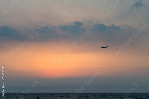 View of the sunset with a flying airplane © 안구정화