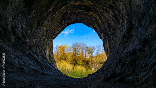 Obraz na płótnie Panoramic view out of the mouth of the “Grürmannshöhle“, a big cave in Iserlohn (Sauerland, Germany) used as shelter by bronze time men near river Lenne
