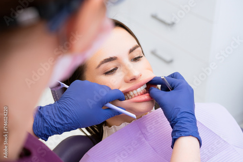 The dentist examines the patients bite at the dental office. 