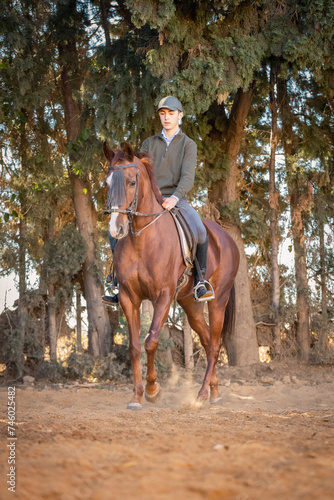 chico joven adolescente con gorra montando a caballo 