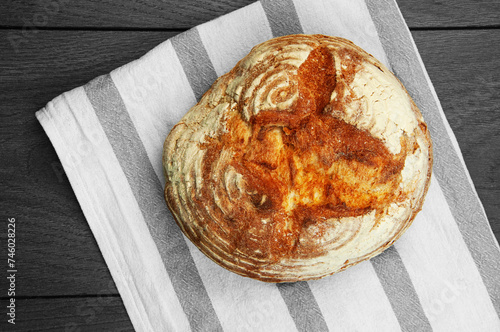 baked Italian bread on a dark wooden table. ciabatta on a white towel on a wooden background	