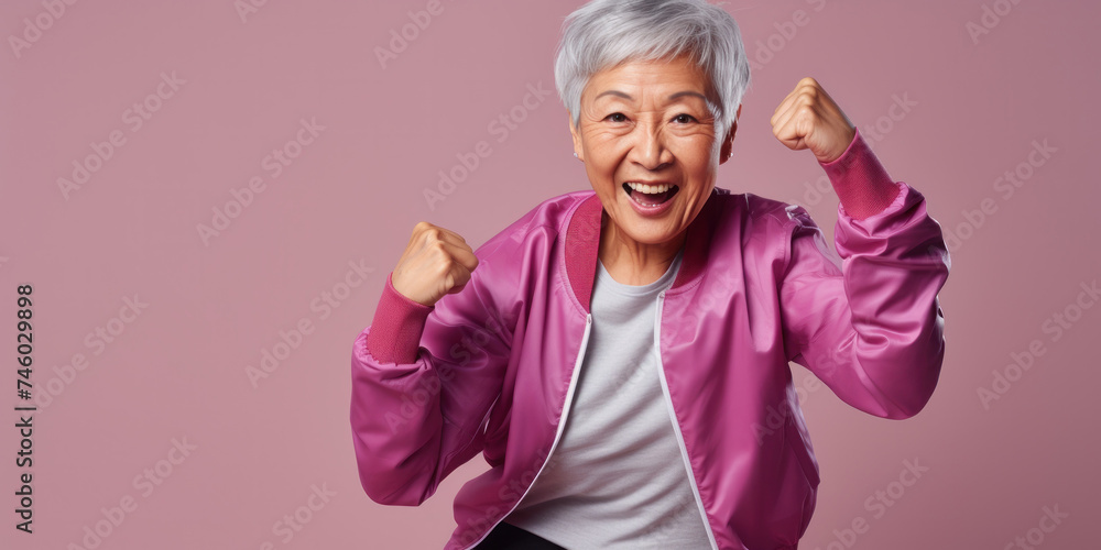 Stylish Asian senior woman in casual clothes on pink background. Fashion advertising banner mockup with blank space for product placement or text. Stylish Asian senior woman in casual clothes on pink background. Fashion advertising banner mockup with blank space for product placement or text.