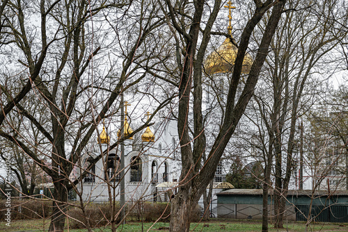 The Orthodox Church is visible behind the leafless trees of the park.