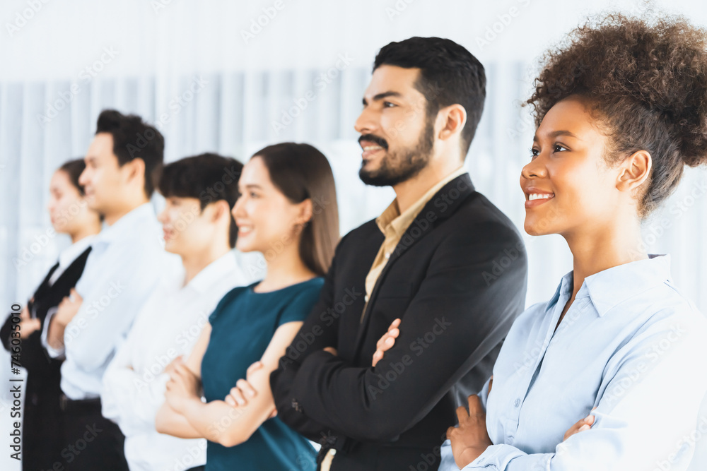 Diverse group of professional business people stand in line with cross arm gesture in modern corporate office. Happy and smiling multiracial office worker team bond and succeed together. Concord