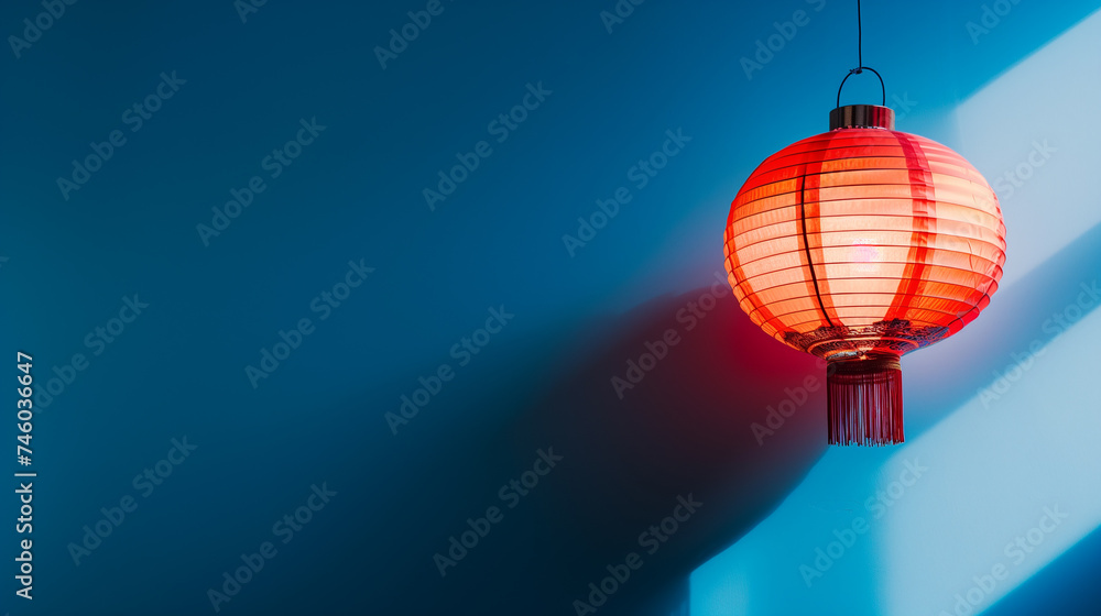 Obraz premium Red Chinese lanterns and paper flowers to celebrate the Chinese New Year on blue background. Place for text. Copy space