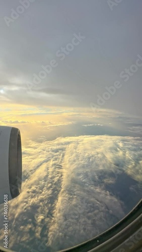 Looking out of window of flying at sunrise airplane. Point of view 4k video footage of amazing scenery during flight. Beautiful sunrise or sunset orange and blue sky outside of passenger air jet photo