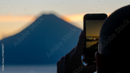 Man taking photo of volcano in Lake Atiltlán 