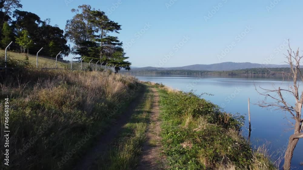 Scenic Lakeside Path with Tranquil Waters and Distant Hills Scenic Lakeside Path with Tranquil Waters and Distant Hills